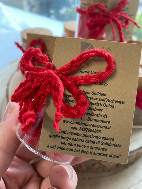 bomboniera barattolo in vetro tondo con tappo in sughero della linea solidale lealiazheimer completo di confezione di confetti, fiocchi di filo catenella in rosso e tag abbinato realizzato per la ricorrenza/cerimonia della Cresima oppure per una Laurea. E' possibile modificare il colore dei fiocchi in base al tipo di cerimonia.