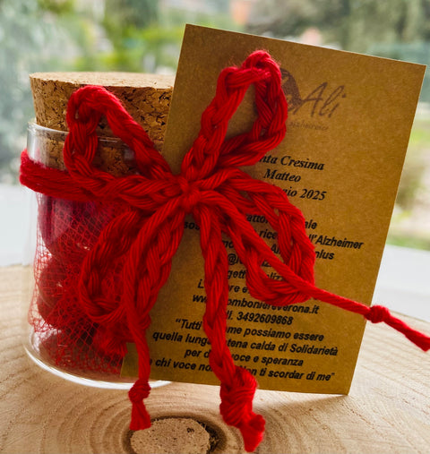 bomboniera barattolo in vetro tondo con tappo in sughero della linea solidale lealiazheimer completo di confezione di confetti, fiocchi di filo catenella in rosso e tag abbinato realizzato per la ricorrenza/cerimonia della Cresima oppure per una Laurea. E' possibile modificare il colore dei fiocchi in base al tipo di cerimonia.