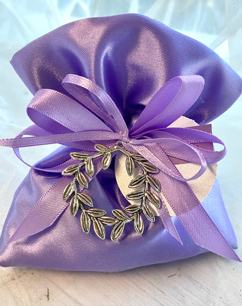 Bomboniera Sacchetto in raso lilla (glicine) con applicato ciondolo corona alloro in metallo completo di aurea a forma di confetti, nastri e bigliettino stampato

Dimensione ciondolo corona alloro: dm 4.
Sacchetto lilla come bomboniera per la laurea indirizzo Lingue.
Possibilità di modificare il colore del sacchetto o nastrini in base all'indirizzo di Laurea.