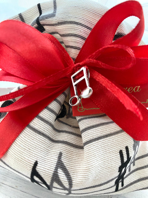 Bomboniera sacchetto in cotone con stampa note musicali in nero completo di confetti, nastrini e bigliettino stampato + piccola applicazione musicale.

Dimensione sacchetto: cm 11 x h 12.

Sacchetto note musicali/musica come bomboniera di Laurea indirizzo musicale.

Possibilità di modificare il colore dei nastrini.