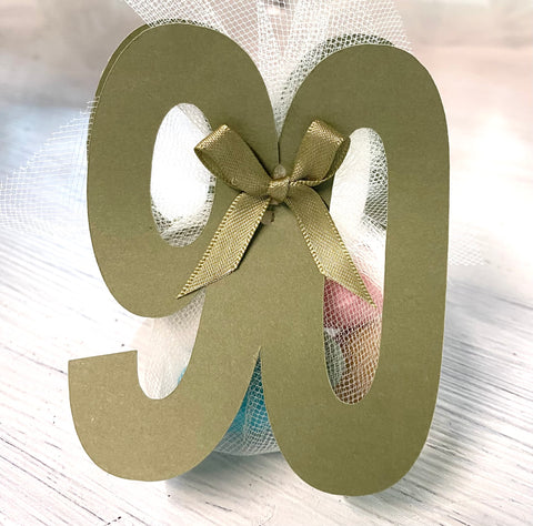 Bomboniera segnaposto NUMERO realizzato in cartoncino colorato completo di confezione di confetti e nastrini abbinati.&nbsp;
Dimensione: cm 7 x h cm 9.
E' possibile realizzare il segnaposto con altri numeri e colori.